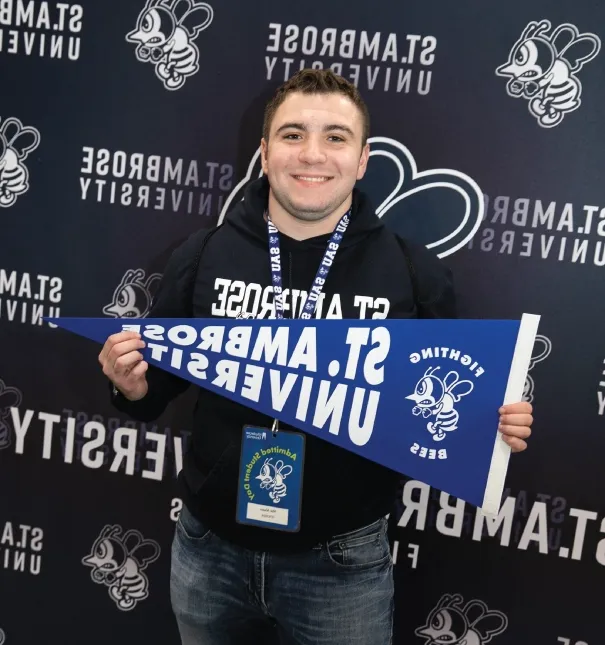 Person wearing SAU merchandise and holding a Fighting Bees pennant.